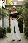 Femme 45 ans pantalon large blanc haut noir sexy en extérieur